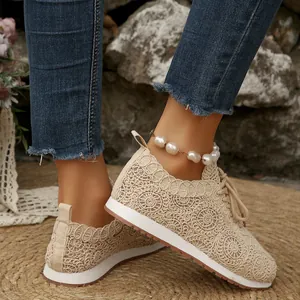 Close-up of beige lace mesh casual sneakers with intricate circular embroidery patterns.