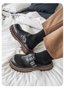 Primer plano de zuecos estilo Birken de cuero negro con hebilla y suela gruesa marrón.