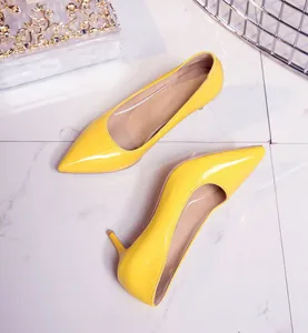 Detailed close-up view of bright yellow pointed-toe pumps with mid-heels on tiled floor.