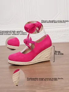Detalle de sandalias de cuña en ante rosa con tacón de esparto de 8 cm y lazo ajustable.