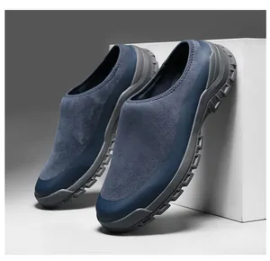 Detailed side view of navy blue suede slip-on clogs for men with thick grey rubber soles