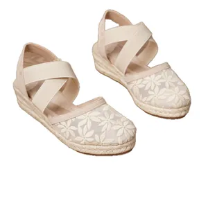 Elegantes sandalias de cuña tipo alpargata beige con bordado floral y tiras elásticas.