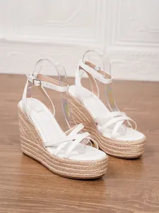 Side view of white platform wedge sandals with braided jute sole detail.
