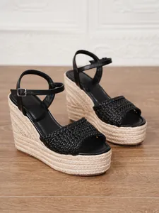 Detalle de sandalias de cuña con plataforma negra y textura de paja trenzada