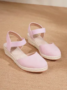 Detalle de sandalias de cuña tipo esparteña rosa con suela de yute y tira elástica