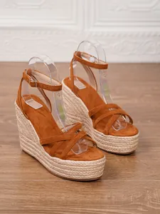 Detailed view of fashionable brown suede espadrille wedge sandals with platform straw sole