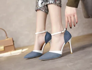 Close-up view of elegant denim pointed-toe stiletto heels with white leather ankle strap