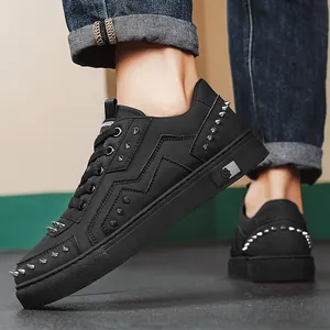 Stylish black low-top men's sneakers featuring decorative silver spikes and leather texture.