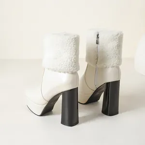 Rear view of cream platform ankle boots with white fuzzy faux fur cuffs and black chunky heels