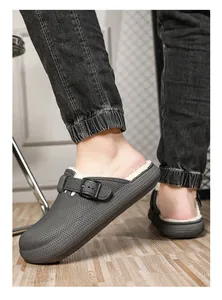 Detail view of men's grey clog slippers with warm white faux fur lining on floor