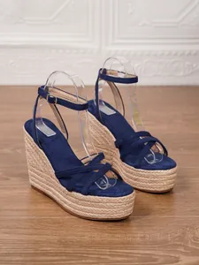 Detailed view of navy blue suede wedge sandals featuring a braided jute platform sole.