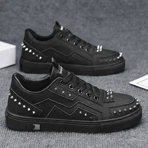 Stylish men's low-top black sneakers featuring decorative silver rivet spikes and studs