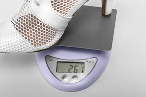 Primo piano dello stivaletto bianco in mesh da 261g su una bilancia digitale di precisione.
