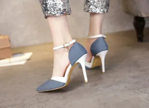 Detailed side view of stylish denim and white pointed toe high heels with a delicate ankle strap