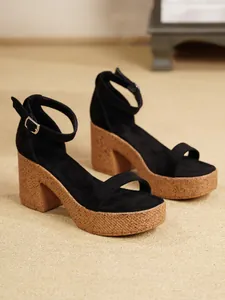 Detalle de las sandalias de plataforma negras con suelas de corcho y correa al tobillo
