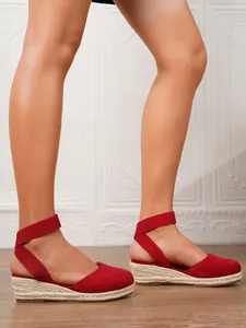 Vista detallada de sandalias de cuña de lona roja con suelas de esparto trenzado y plataforma