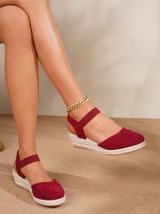 Detalle de sandalias de cuña tipo alpargata burdeos con suela de yute y acabado de gamuza