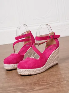 Détail de sandales compensées en daim fuchsia avec plateforme en corde tressée