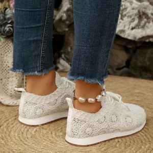 Detailed view of women's white lace mesh casual sneakers with elegant floral patterns