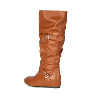 Knee-high slouchy tan leather boot featuring decorative buckle straps and pleated texture