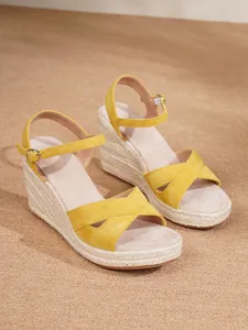 Yellow suede wedge sandals with espadrille platform and adjustable ankle strap for women.