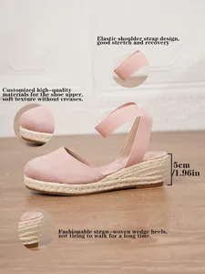 Detalle de sandalias de cuña tipo alpargata rosa con tacón de esparto tejido de 5 cm.