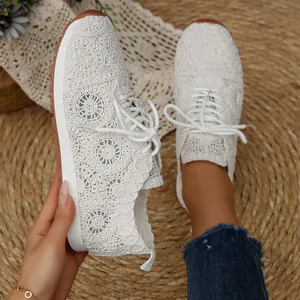 Close-up detail of women's white crochet lace-up sneakers with rustic mesh texture