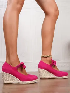 Elegantes alpargatas de cuña fucsia con puntera cerrada y detalle de lazo con plataforma alta