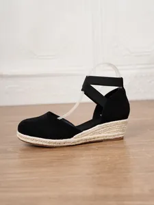 Detalle de sandalias de cuña tipo alpargata negra para mujer con suela de yute natural