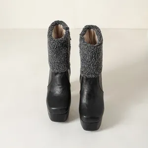 Front view of black leather platform chunky heel boots with grey shearling trim detail