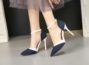 Detail view of stylish denim and white leather pointed toe stiletto heels with ankle strap