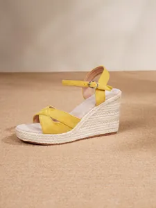 Detail view of yellow crossover strap wedge sandal with braided jute platform
