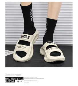 Close-up view of stylish beige EVA slides worn with black socks in a modern studio setting.