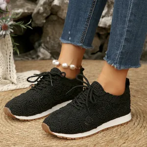 Women's black casual sneakers featuring elegant floral lace mesh upper and secure lace-up closure