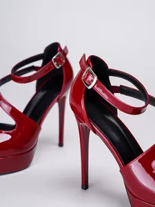 Detailaufnahme von eleganten roten Lackleder-High-Heels mit verstellbarem Knöchelriemen