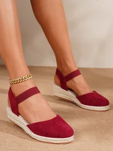 Detalle de sandalias de cuña espadrilles en ante rojo con correa elástica al tobillo
