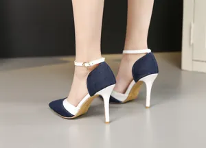 Detailed view of denim pointed-toe stiletto heels with elegant white ankle strap and charm