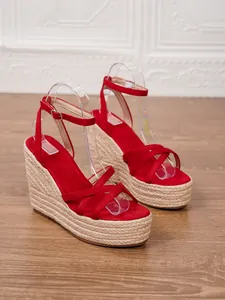 Stylish red suede espadrille wedge sandals with woven platform and ankle straps.