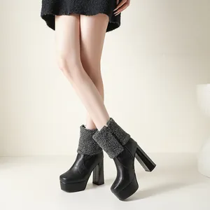 Detail view of black chunky heel platform ankle boots with grey fuzzy knitted cuff on model