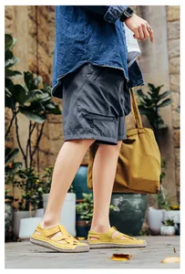 Elegantes sandalias planas tejidas amarillas para mujer en un entorno exterior