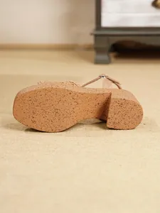 Detalle de cerca de la suela de plataforma con patrón de corcho en sandalias de cuña de mujer