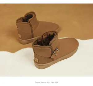 Close-up of brown suede snow boots with side buckle and plush lining detail