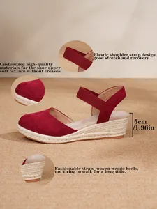 Vista detallada de las sandalias de cuña de esparto en ante rojo con correas elásticas.