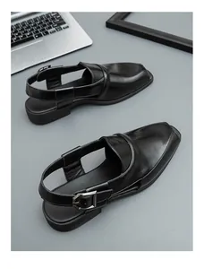 Detalle de sandalias de cuero negro brillante para hombre con hebilla y diseño transpirable