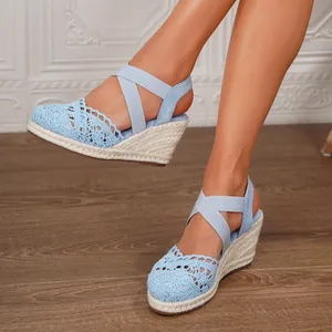 Sandalias de cuña de ganchillo azul claro con tiras elásticas y tacón de esparto.