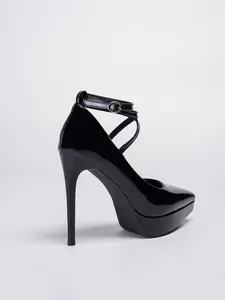 Vista lateral detallada de tacones de aguja en charol negro con plataforma alta