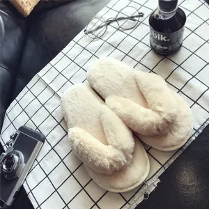 Detailansicht von cremefarbenen Kunstpelz-Flip-Flops mit dicker, rutschfester Sohle