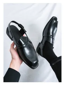 Detalle de sandalias de cuero negro brillante para hombre con cierre de hebilla atrás.