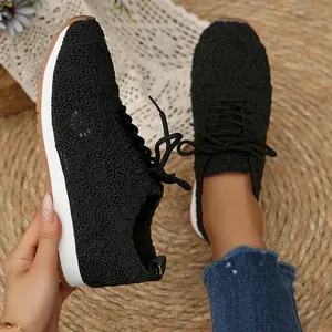 Close-up of women's black lace mesh sneakers with intricate floral pattern embroidery