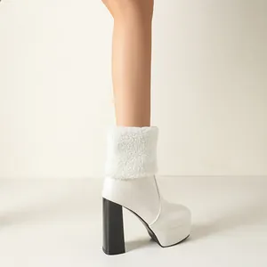 Close-up detail of a white platform ankle boot featuring a black thick heel and fur trim